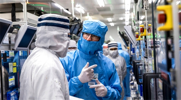 팀쿡 애플 CEO(파란색 방진복)가 오필름의 카메라 모듈 공장을 둘러보고 있다.