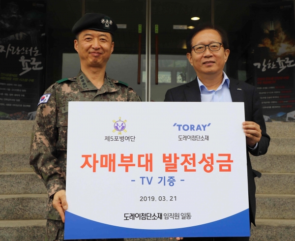 이승훈 도레이첨단소재 인사지원본부장이 김남훈 육군 제5포병여단장에게 발전기금을 전달하고 있다.