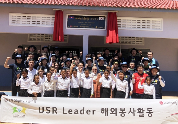 권동섭 LG디스플레이 노동조합 위원장(둘째줄 오른쪽에서 세번째) 등 직원과 관계자가 캄보디아 씨엠립 지역의 프러닥 (Pradak) 초등학교에서 '희망교실' 기증식을 열고 기념촬영을 하고 있다