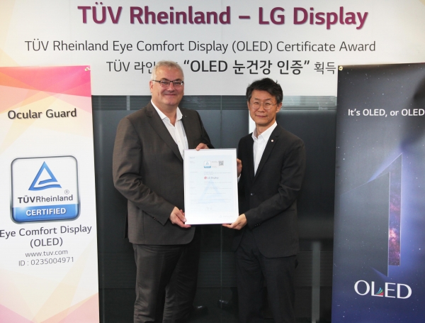 오창호 LG디스플레이 TV사업부장(부사장)과 홀거 쿤즈(Holger Kunz) TUV 라인란드 제품인증 사업부문 회장이 TV용 OLED 패널의 '아이 컴포터 디스플레이(Eye Comfort Display)' 인증을 기념해 사진을 찍고있다.