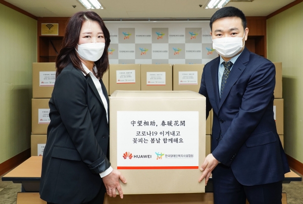 멍 샤오윈 한국화웨이 CEO(오른쪽)가 정은영 한국장애인복지시설협회 부회장에게 마스크를 전달하고 있다.