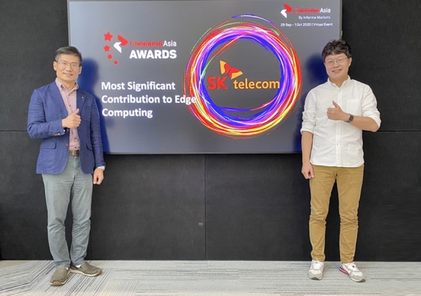 이동기 SK텔레콤 5GX 클라우드랩스 PL(오른쪽)과 신상호 매니저가 '커뮤닉아시아 아시아 어워드 2020(CommunicAsia Award 2020)' 수상 화면 앞에서 기념 촬영하고 있다.