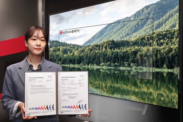 LG디스플레이 직원이 유기발광다이오드(OLED) TV 앞에서 SGS 친환경제품 인증서를 선보이고 있다.